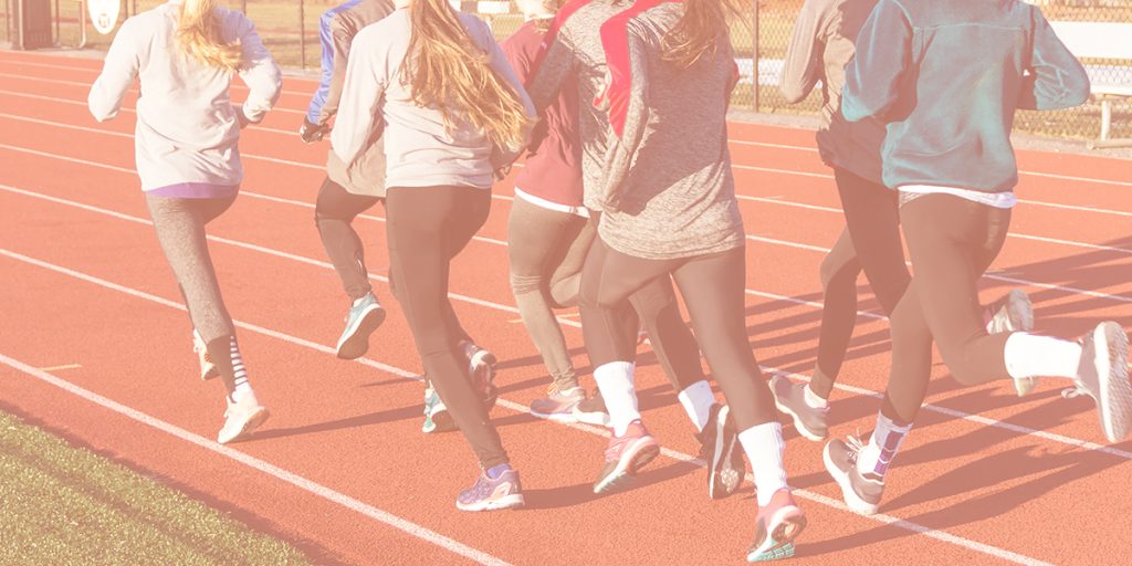 a group of teens running on a school track