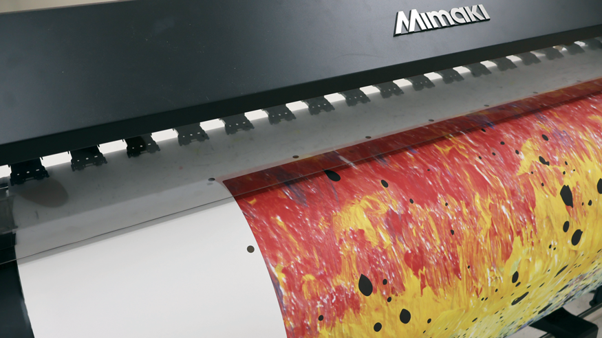 detail of a mimaki printer printing a colorful pattern on paper